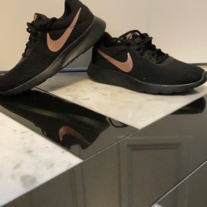 Women’s black Nike sneakers with gold Nike accent